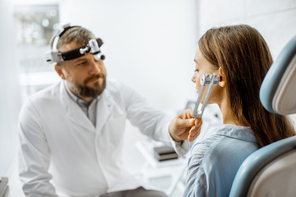 Médico fazendo um teste de audição em uma paciente