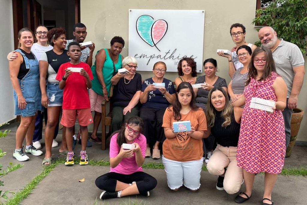 Diversas mães e crianças em frente ao instituto Empathiae, segurando os artesanatos que fizeram