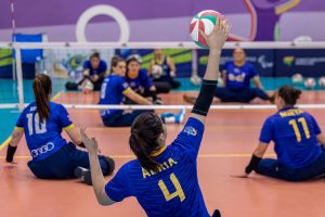 Foto do treino da Seleção Feminina de Volei Sentado no CT Paralímpico, em São Paulo. Em close vemos a atleta Adria esticando a mão para cima para bater na bola.