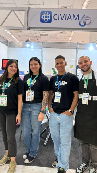 Foto de Mariana, Mirella, Bruno e Caio posando em frente ao estande da Civiam