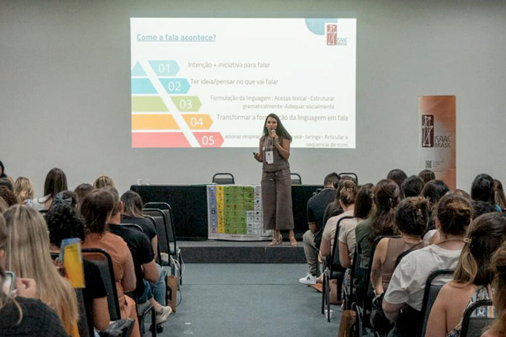 Foto de Ana Philips dando uma palestra em um evento do ISAAC Brasil sobre processamento de linguagem e CAA
