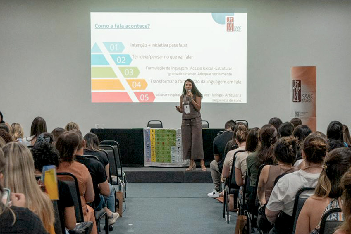 Foto de Ana Philips dando uma palestra em um evento do ISAAC Brasil sobre processamento de linguagem e CAA