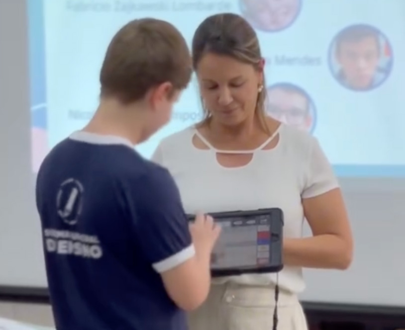 Criança falando através de um tablet de CAA