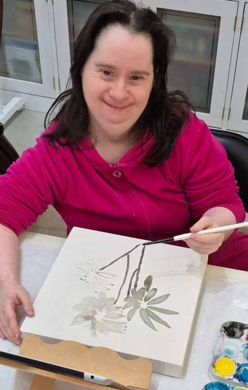 Foto de Tatiana pintando uma aquarela com flores