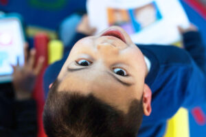 Aluno olhando para cima e sorrindo com Atividades adaptadas com Comunicação Aumentativa e Alternativa na volta às aulas