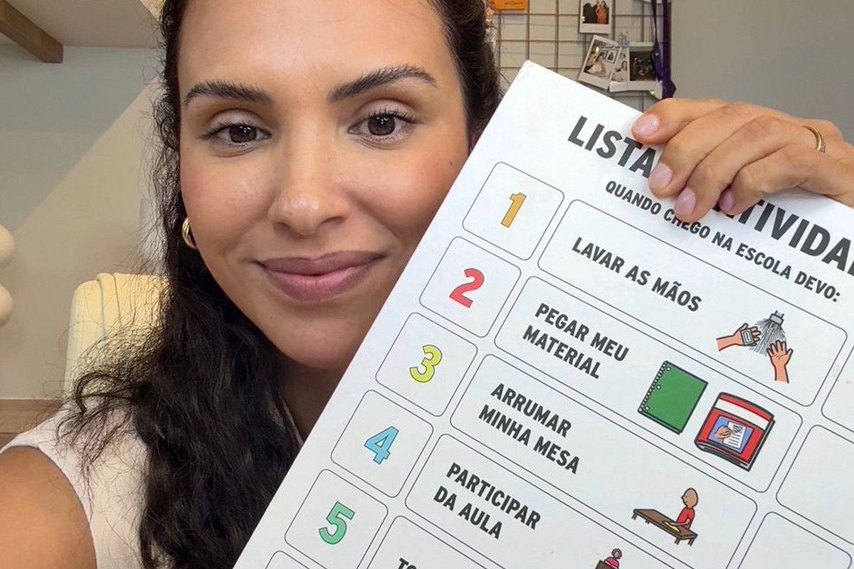 Foto da fono Ana Philips segurando um quadro de rotina em CAA