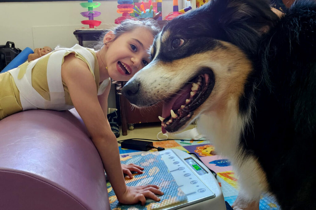 Foto de Júlia fazendo terapia ao lado de sua companheira canina Léia