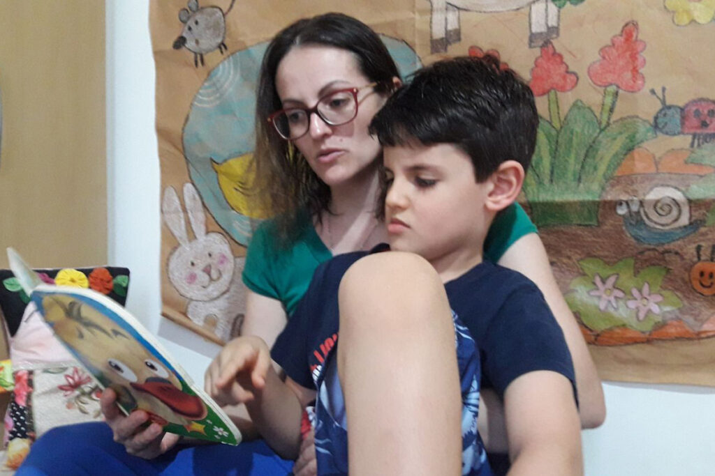 A mãe Giselle com o filho autista Pedro trabalhando comunicação alternativa