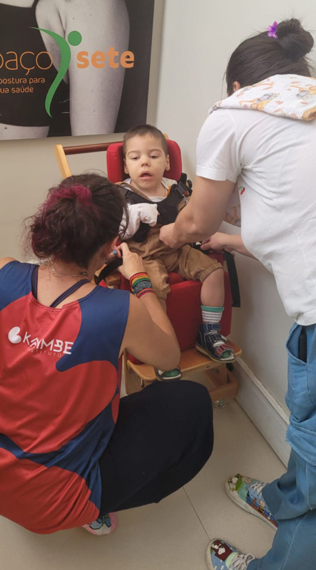 Foto de Dafne adaptando um cadeirão para uma criança em um mutirão