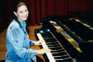 Foto de Gisele tocando piano quando mais nova