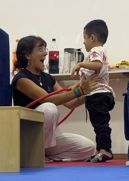 Foto de Dafne segurando um garotinho junto com um bambolê