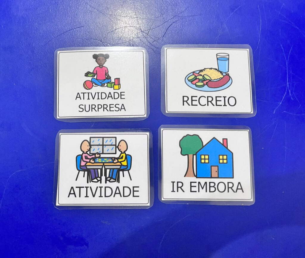Foto de alguns pictogramas de CAA em cima de uma mesa azul
