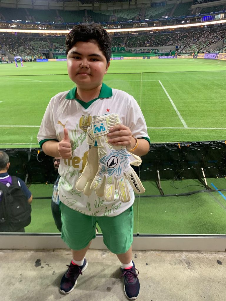 Foto de gustavo no estádio do Palmeiras com a luva assinada do Weverton